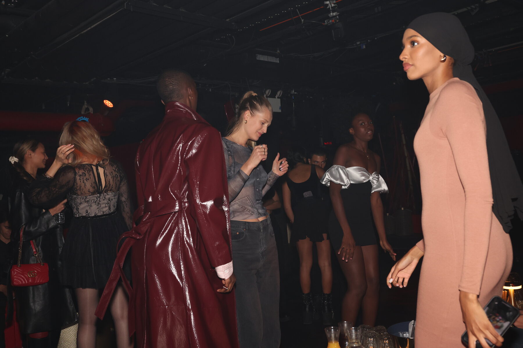 Models walking in a red-lit venue during NY Fashion Week